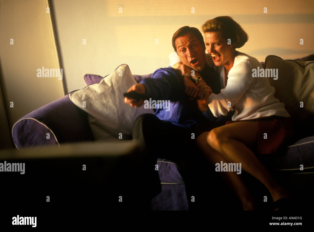 COUPLE WATCHING TELEVISION Stock Photo