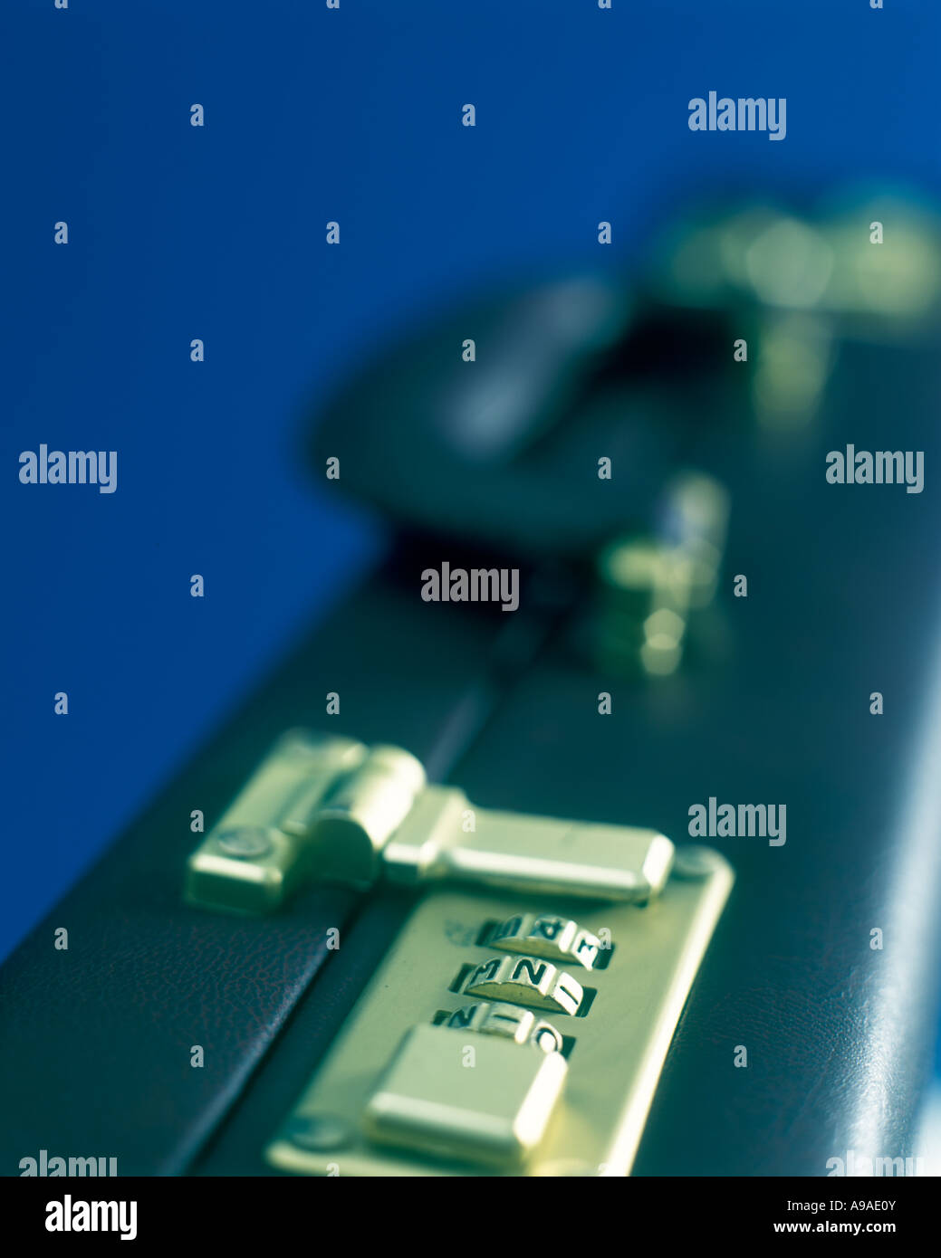 COMBINATION LOCK ON BRIEFCASE ON PLAIN DARK BLUE BACKGROUND Stock Photo