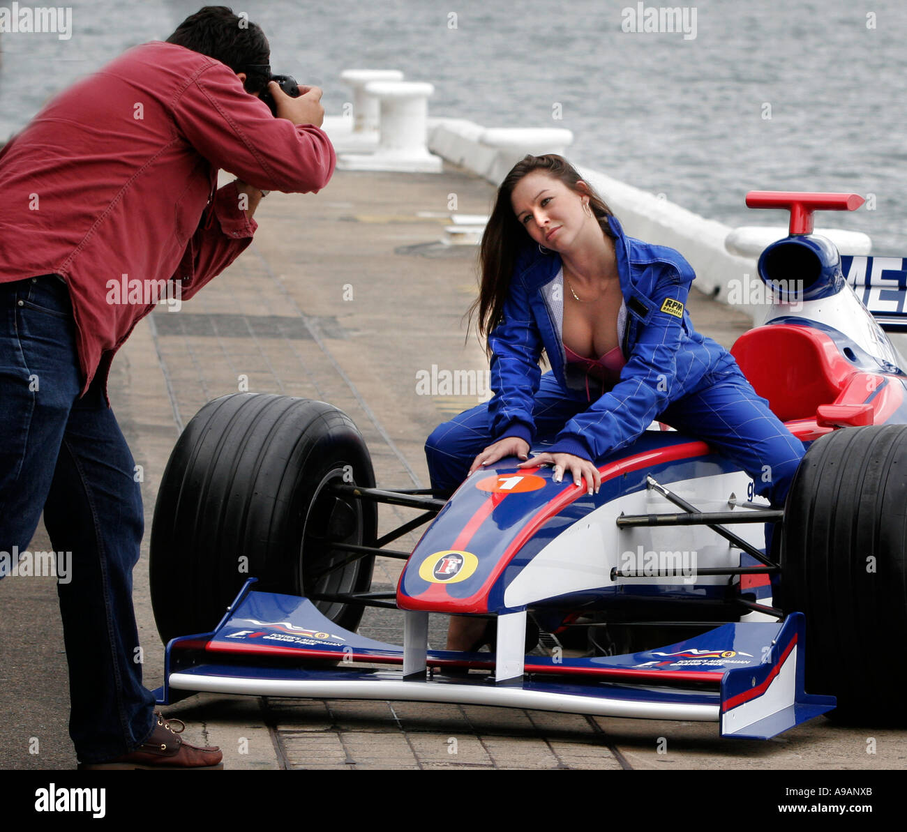 Racing cars and sex. A model poses for photographers on the bonnet of a  Formula One racing car Stock Photo - Alamy