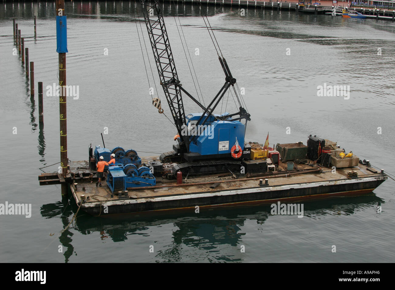 Working barge with Pile driving equipment at work in a marina at Stock