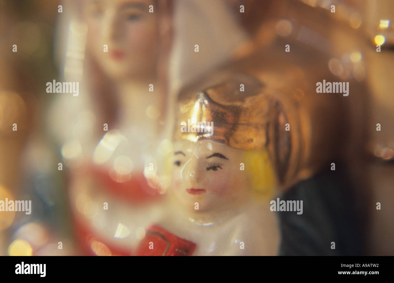 Close up of a china model of the Virgin Mary sitting on a throne with a crowned infant Jesus Christ in warm light Stock Photo
