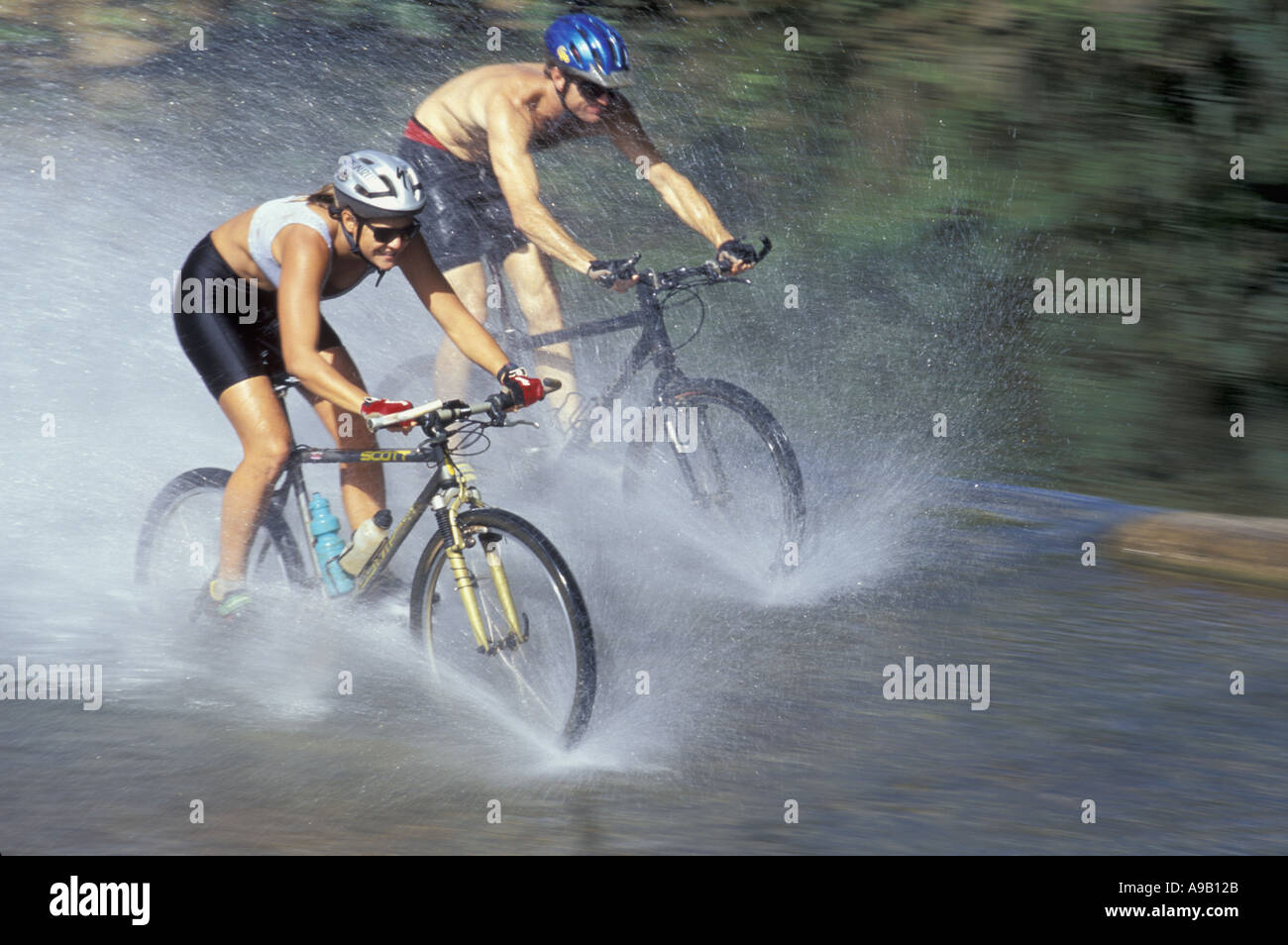USA Hawaii Kauai couple mountain biking through stream Stock Photo Alamy