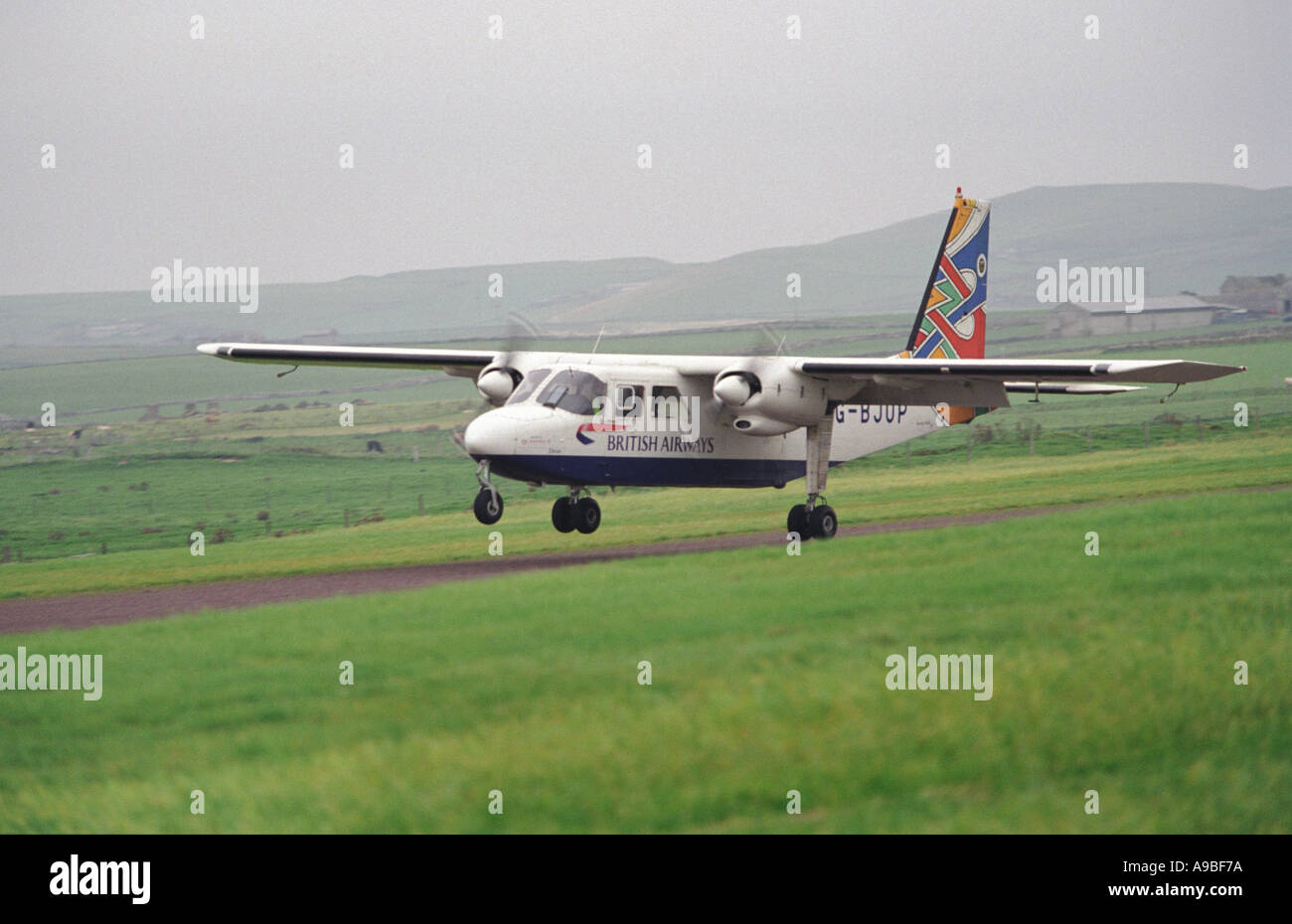 Britten Norman Islander aircraft lands on a grass strip on the Orkney Island of North Ronaldsay Stock Photo