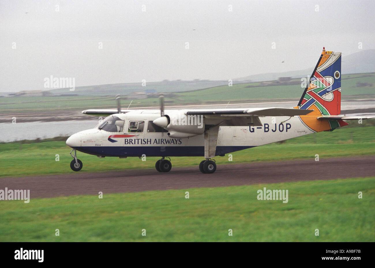 Britten Norman Islander aircraft lands on a grass strip on the Orkney Island of North Ronaldsay Stock Photo