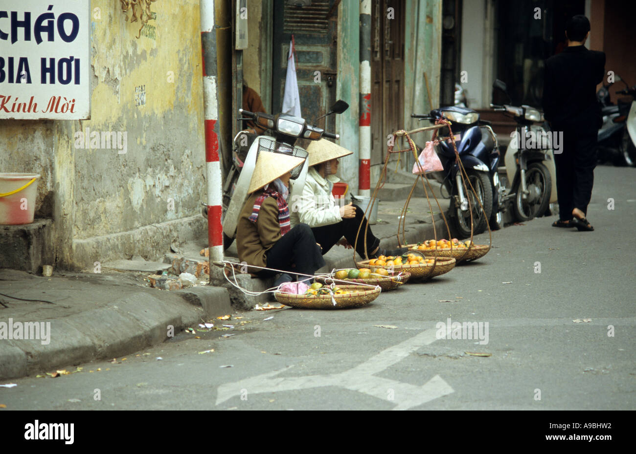 Two women selling fruit, Phu Doan St, Hanoi Old Quarter, Viet Nam Stock Photo