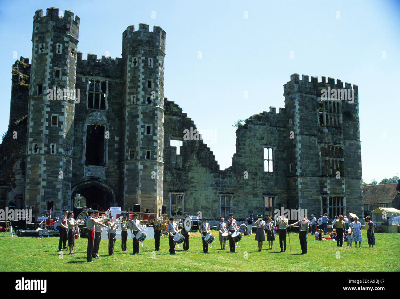 Midhurst West Sussex UK boys band playing in the grounds of Cowdrey Castle , the burnt out ruins of the castle in the background Stock Photo