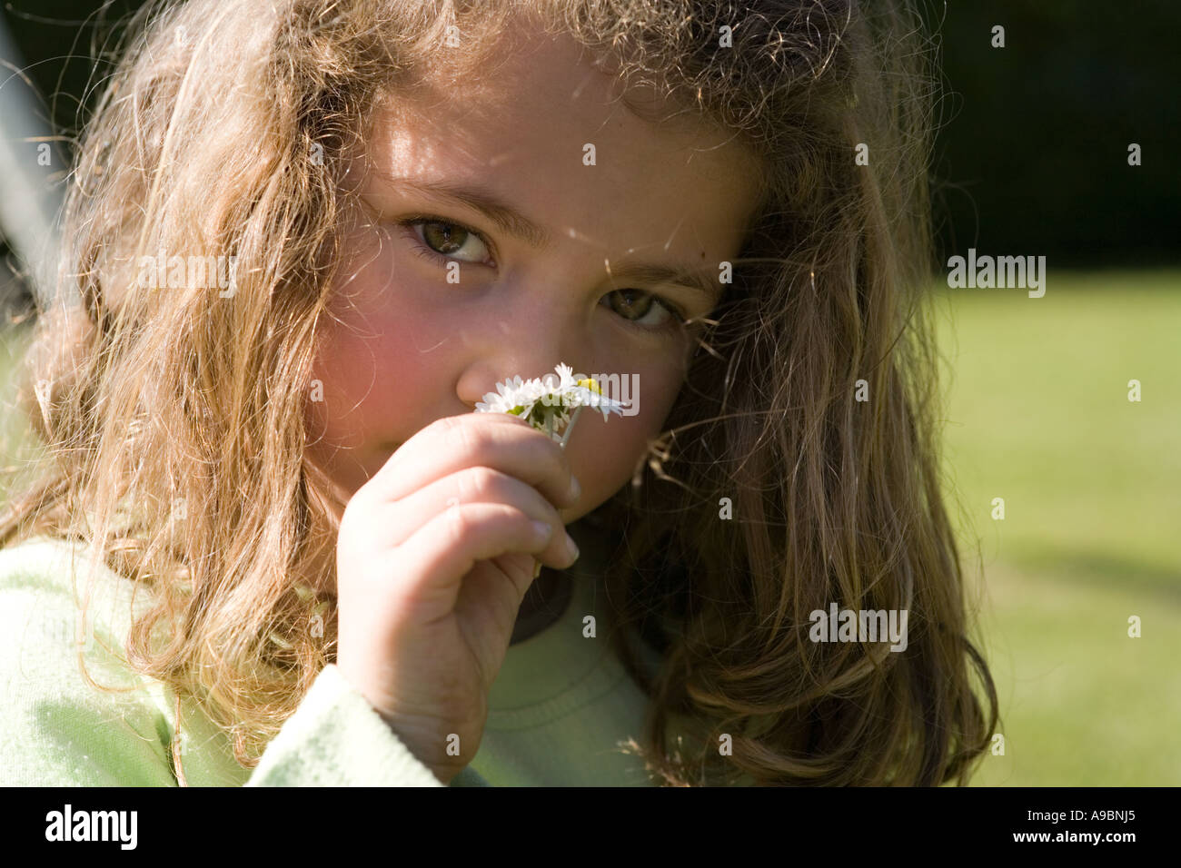 Little girl smelling a flower Stock Photo - Alamy