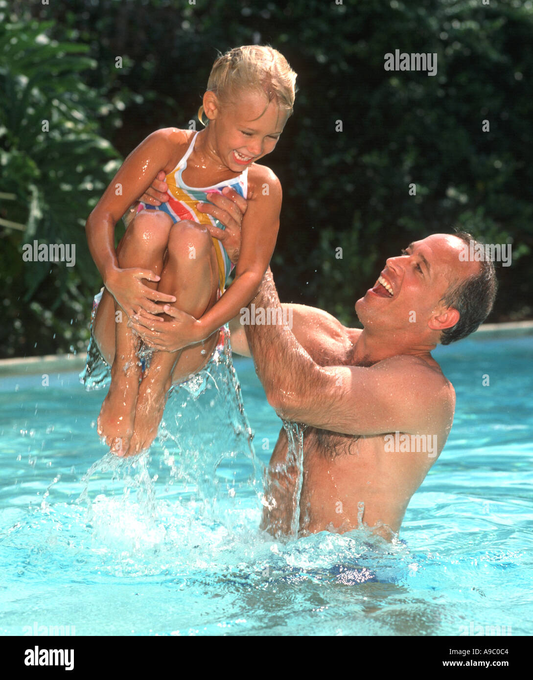 father lifting daughter into the air in swimming pool Stock Photo - Alamy