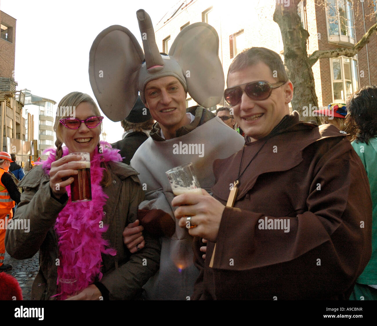 Young people dressed up for the Duesseldorf carnival celebrations, drinking alt beer outside Uerige pub 2007 Stock Photo