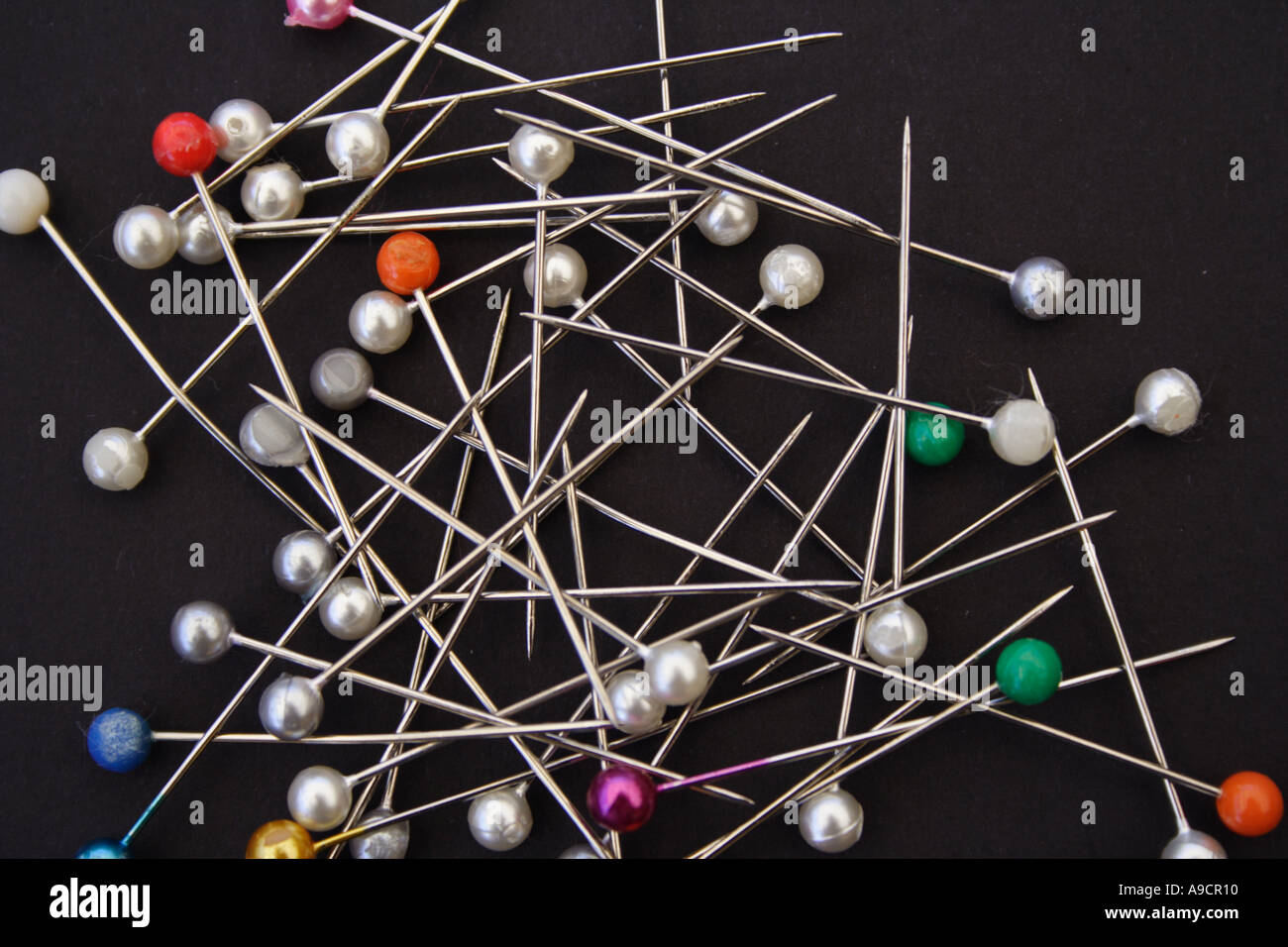 A PILE OF COLOURED PINS ON A BLACK BACKGROUND BAPD1476 Stock Photo - Alamy