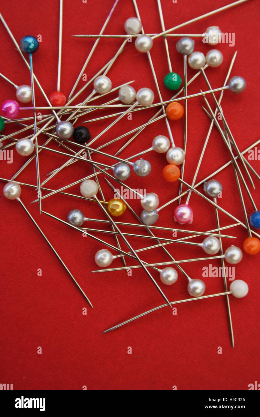 A PILE OF COLOURED PINS ON A RED BACKGROUND BAPD1493 Stock Photo - Alamy