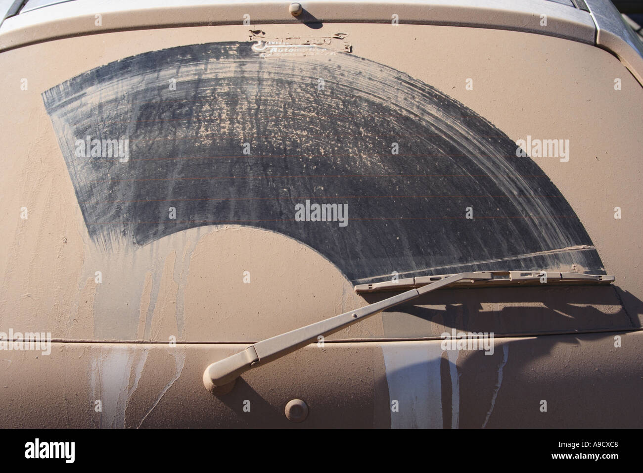 A HEAVY LAYER OF DUST ON THE BACK WINDSCREEN OF A CAR OUTBACK Stock