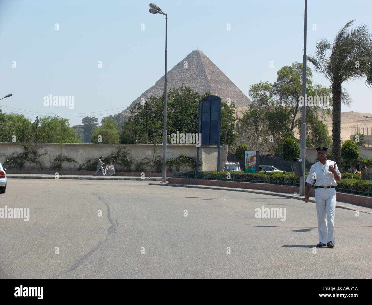 pyramids at Gisa seen as driving past from Cairo with tourist police approaching Stock Photo