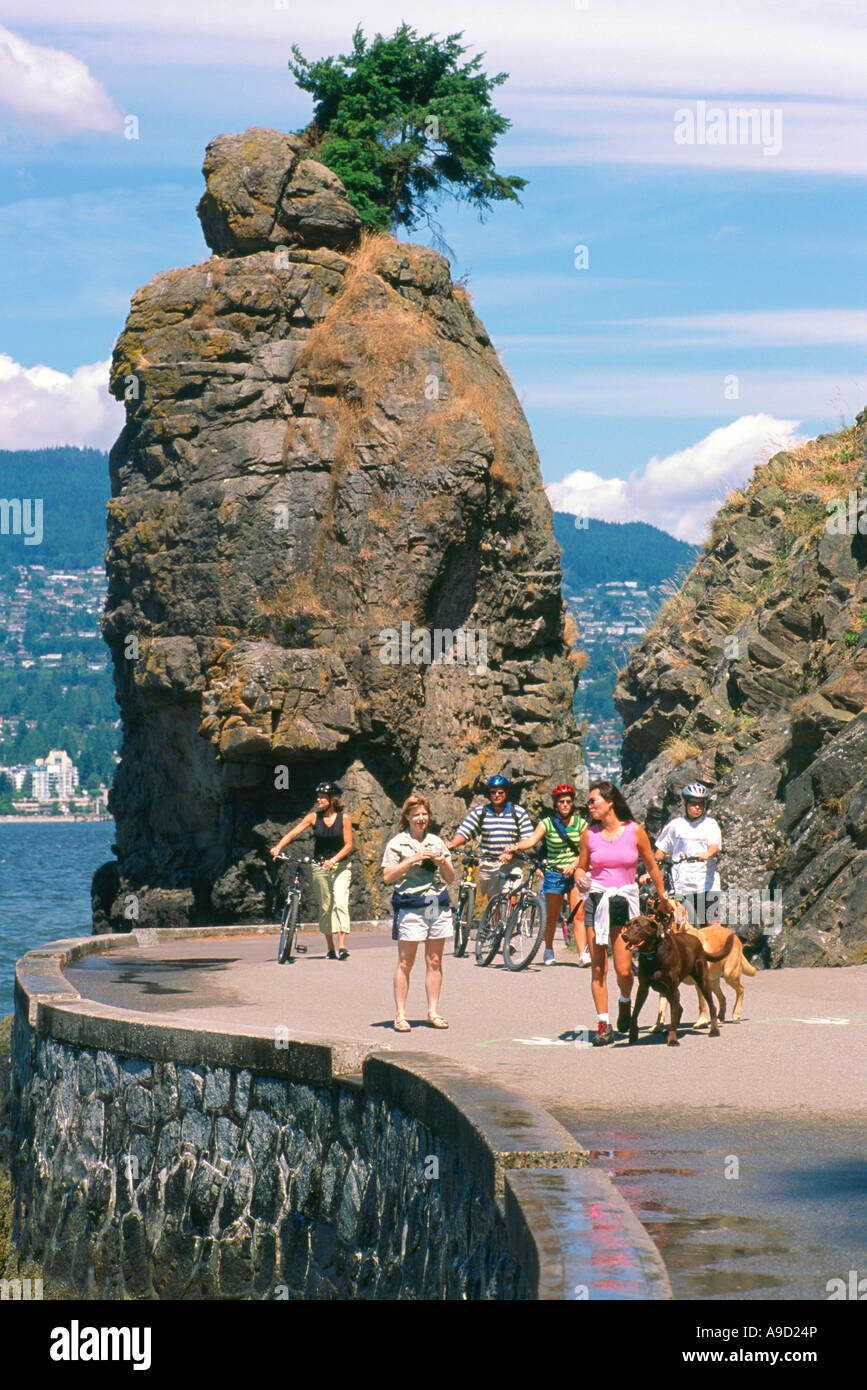 People walking along the Stanley Park Seawall at "Siwash Rock" and