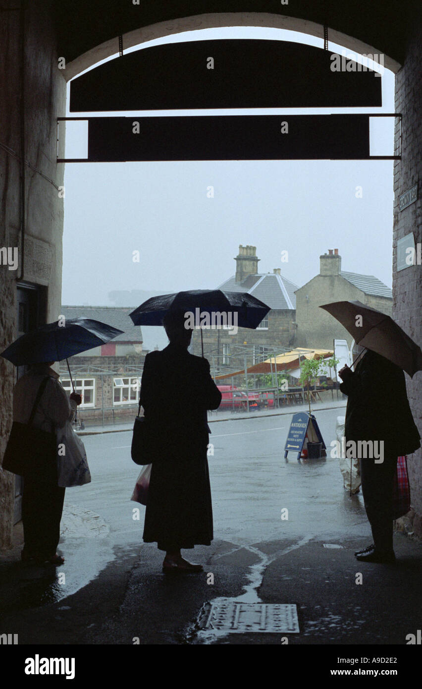 3 women sheltering from a sudden storm Stock Photo