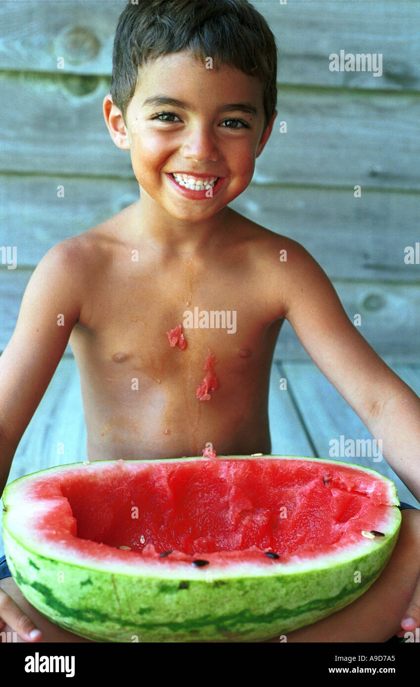 boy looks up after eating half a watermelon Stock Photo Alamy
