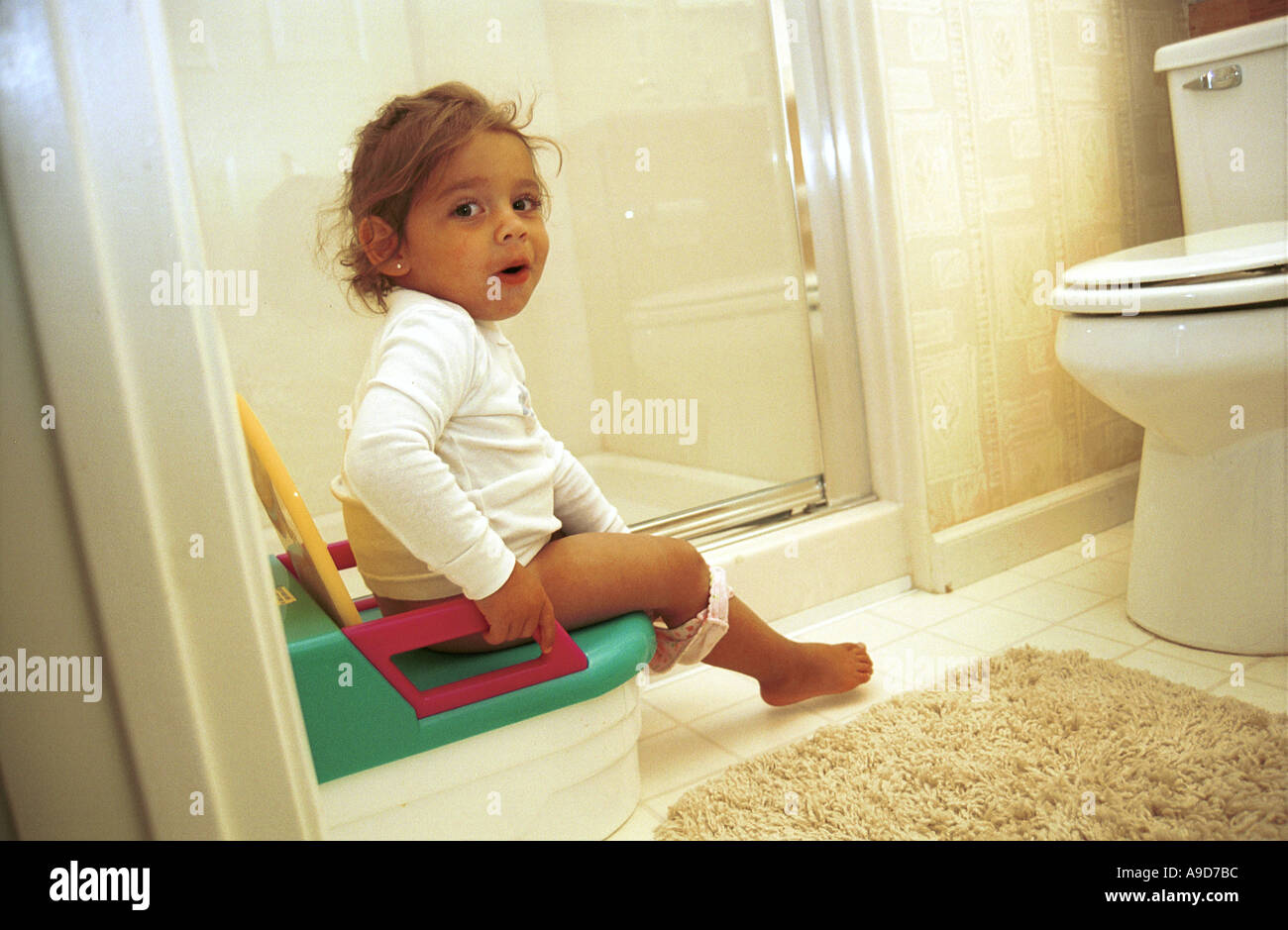 Young Girl Uses Her Potty Trainer To Go To The Bathroom Stock Photo Alamy