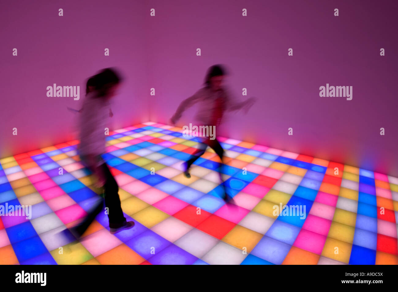 Two young girls playing on illuminated squares art artwork in Guggenheim Museum and Art Gallery New York City NY NYC USA Stock Photo