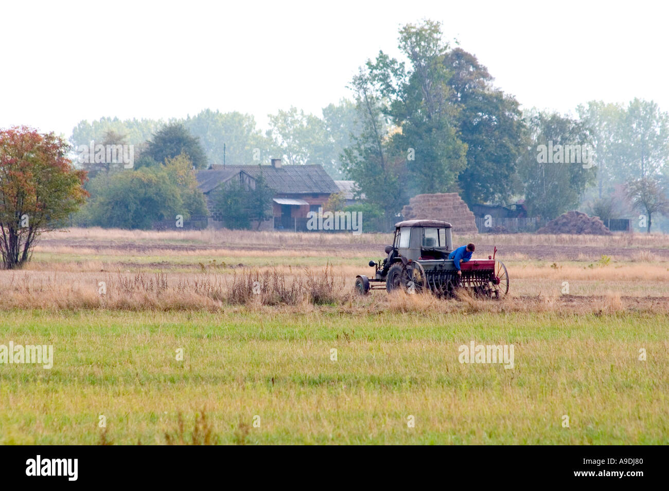 Farmers working in the field with tractor and farm implement. Zawady Poland Stock Photo