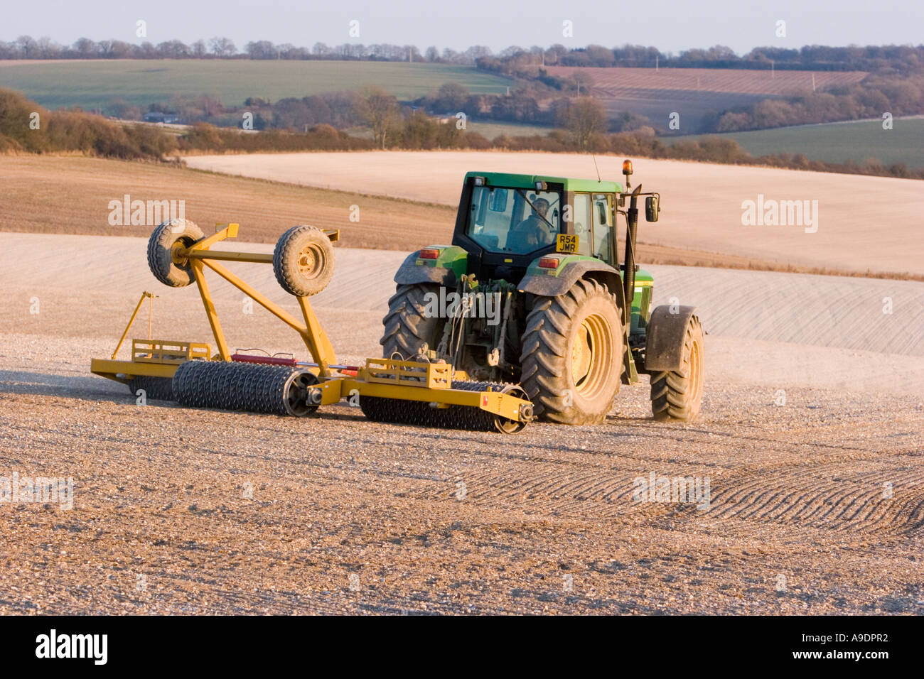 Tractor raking chalky soil in field Stock Photo - Alamy