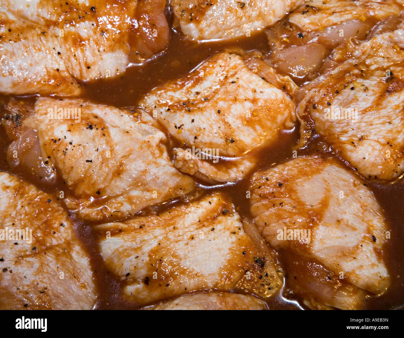 Chicken pieces marinating in honey and orange sauce for barbecue Wales UK Stock Photo