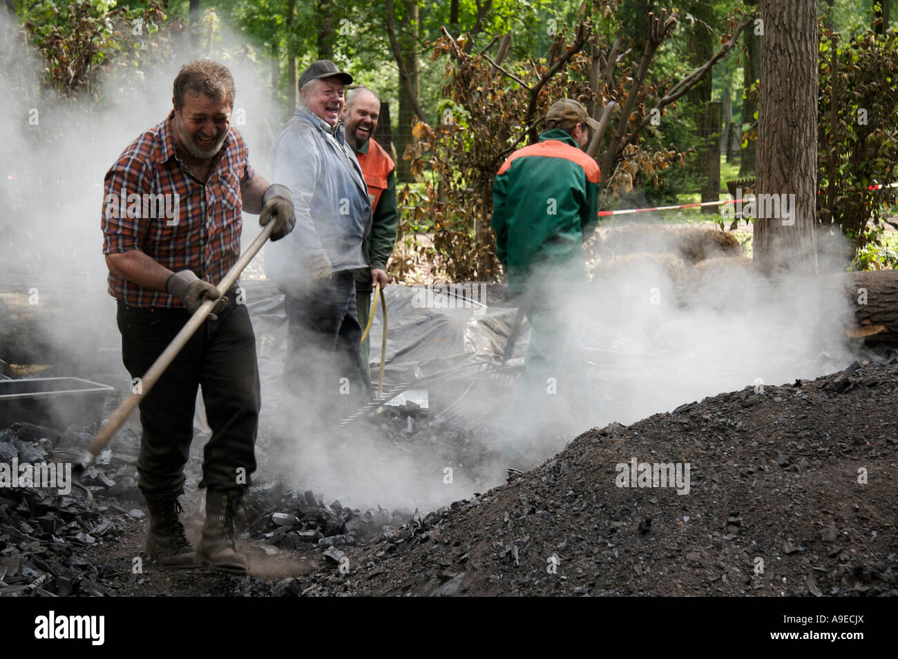 Craftsmen separating charcoal from a meiler Stock Photo