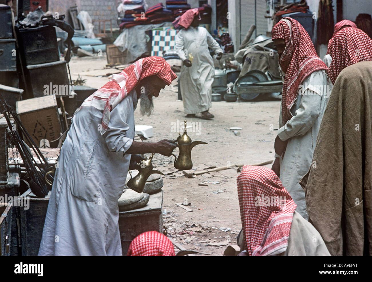 Saudi Arabia, Riyadh. A market seller offers a coffee pot for sale in