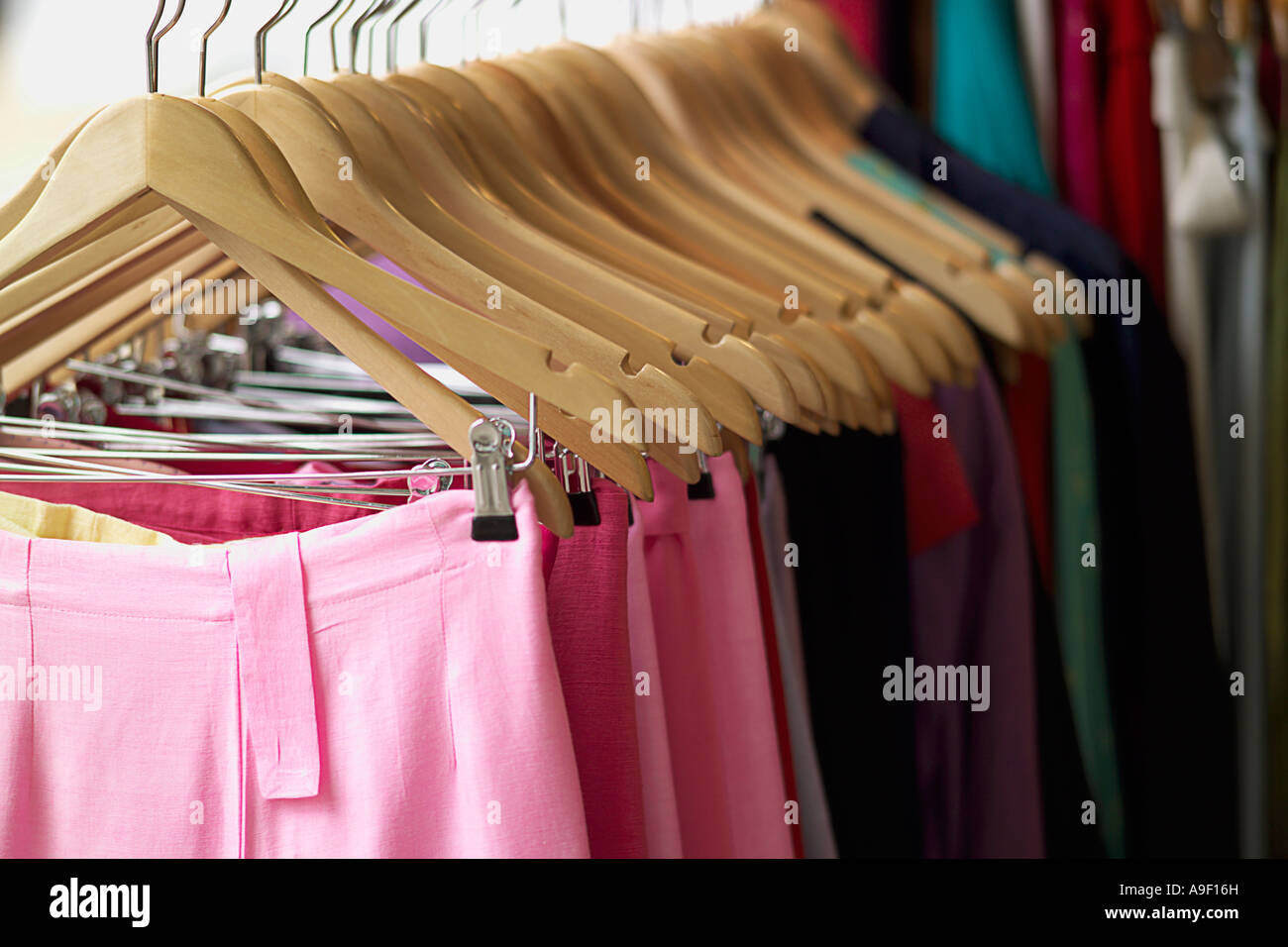 ROW OF CLOTHES HANGERS WITH PINK SKIRTS Stock Photo