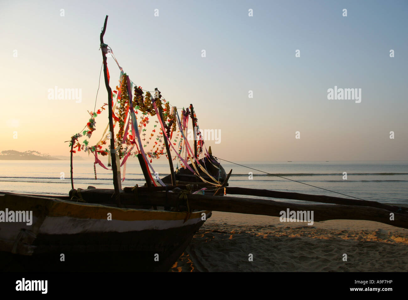 A fishermans boat decorated with flower garlands on the beach in Palolem in Southern Goa, India Stock Photo