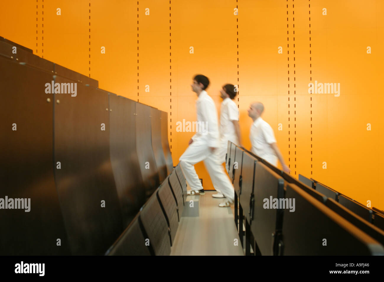 Three men walking up stairs in theatre Stock Photo - Alamy
