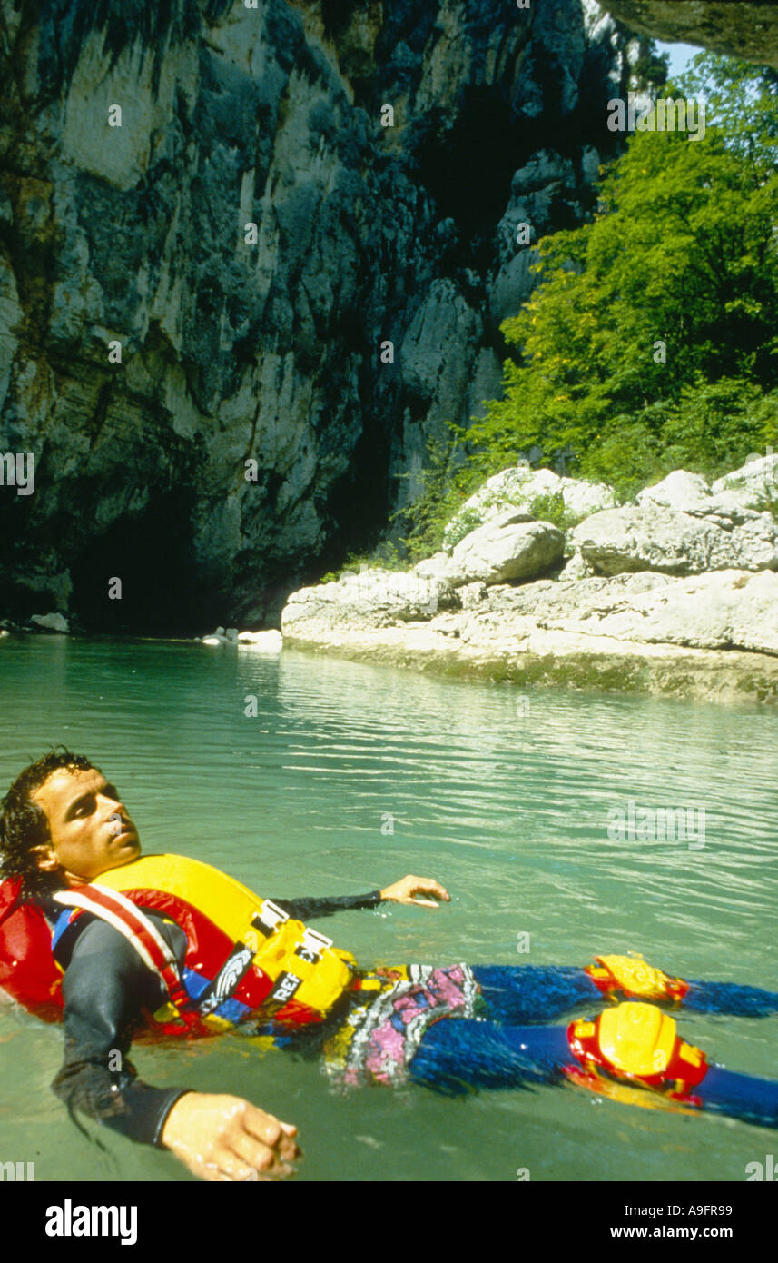 canyoning, man with protection clothings lying on bach in river. Stock Photo