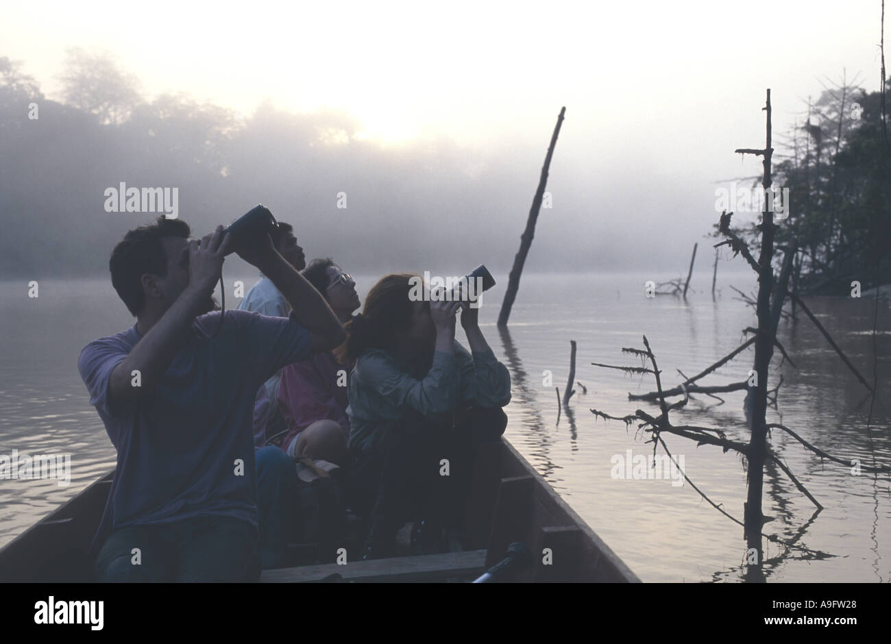 ecotourism, tourists watching from a boat, Borneo. Stock Photo