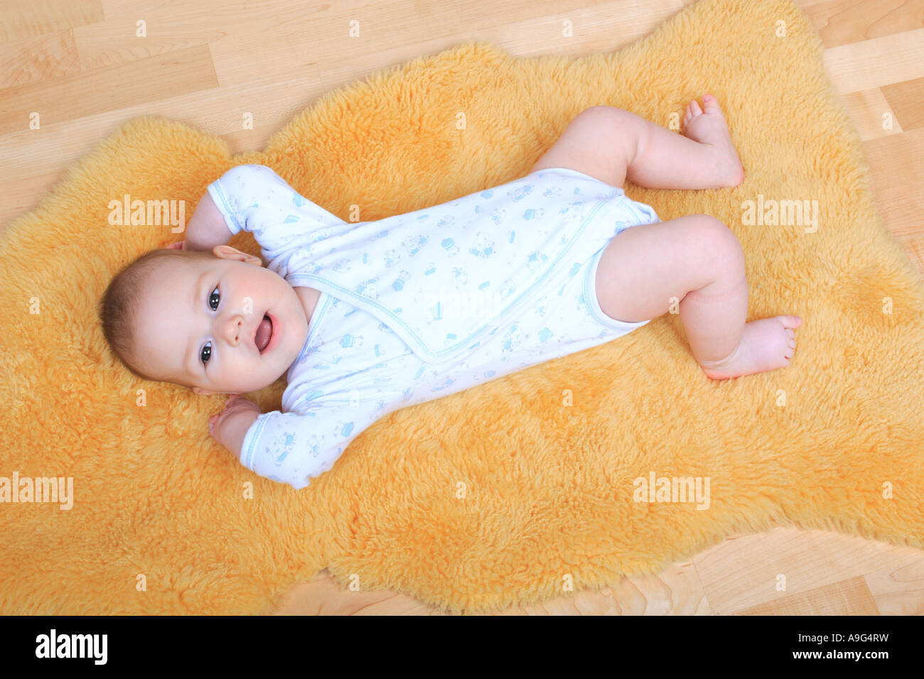 baby lying on a sheepskin rug Stock Photo Alamy