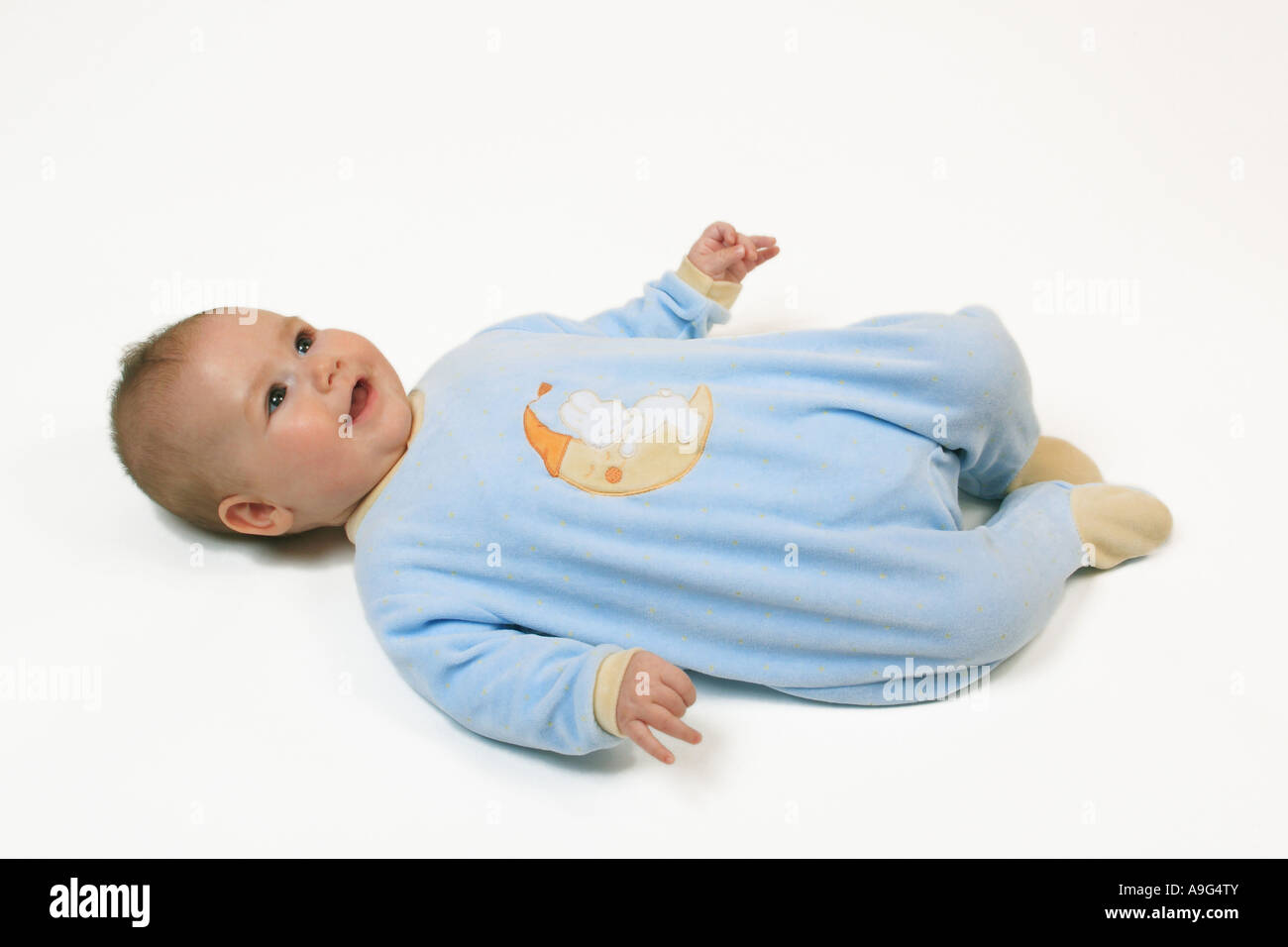 Baby lying on back, wearing a romper suit Stock Photo