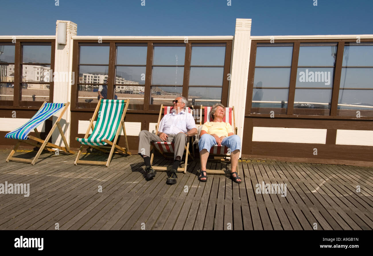 mature couple sitting in deck chairs on Worthing Pier Stock Photo - Alamy