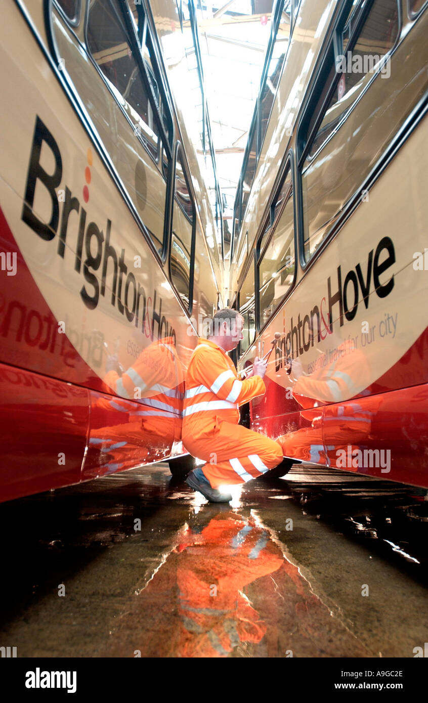 Two newly painted double decker buses get their lettering applied by a ...