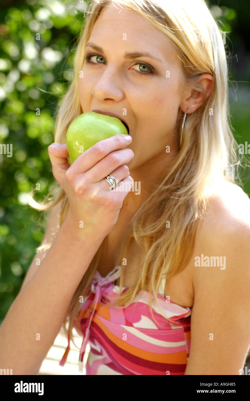 blond woman eating apple. Stock Photo