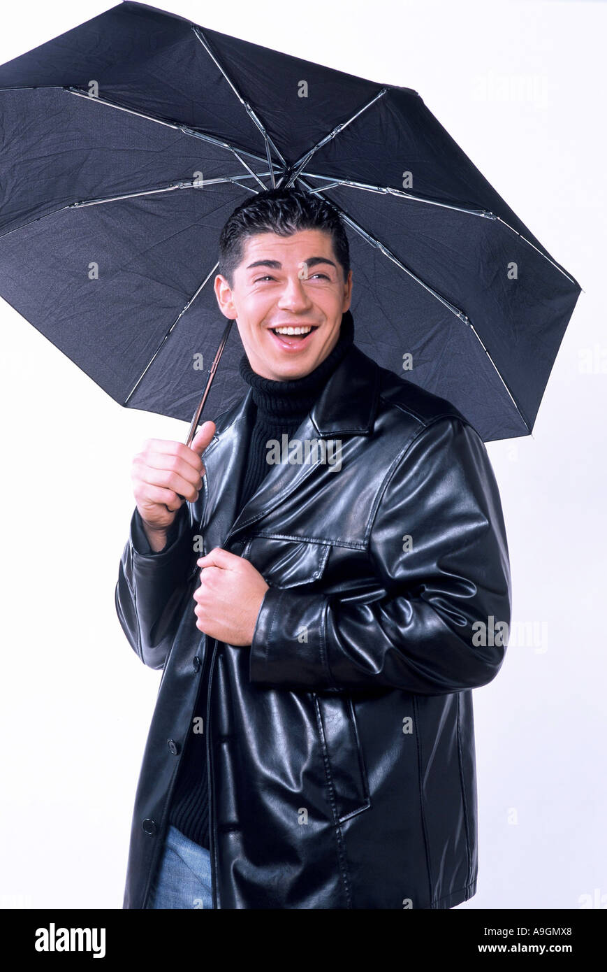 young man with umbrella, wearing leather jacket Stock Photo