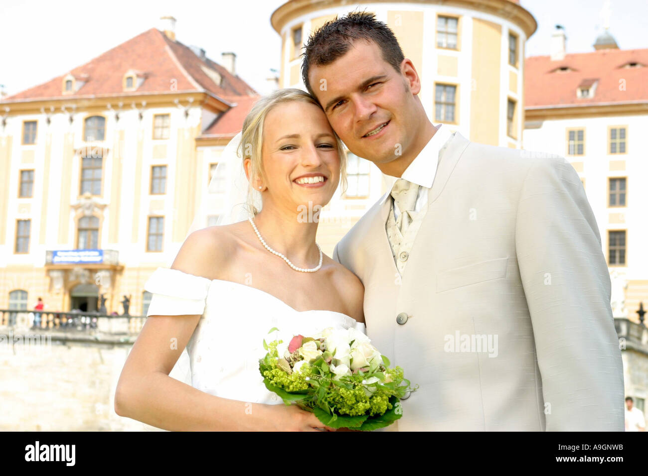 young wedding couple posing for wedding photography, groom wearing suit, bride wearing wedding dress, head to head Stock Photo