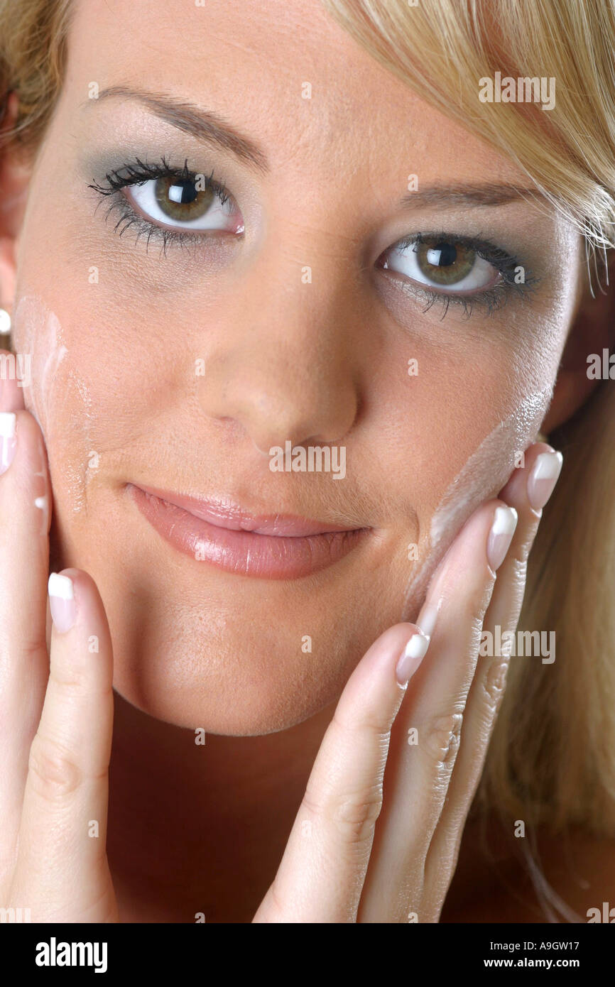 blond woman , applying humidity cream on her face. Stock Photo