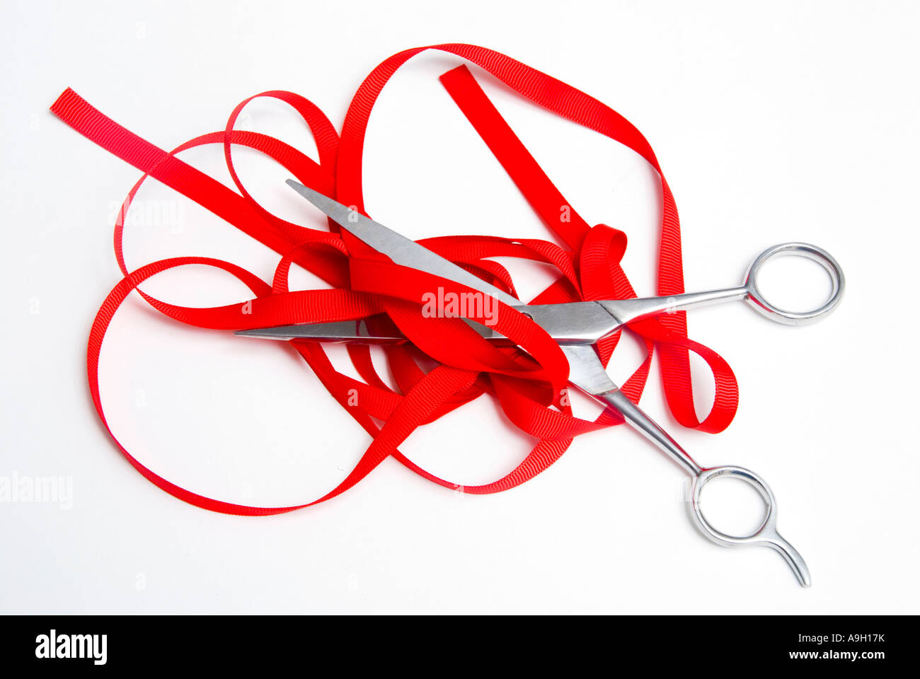 Cutting red tape with scissors Stock Photo