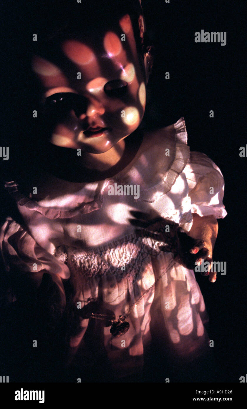 scary doll in the dark with patterned light shining on its face Stock Photo
