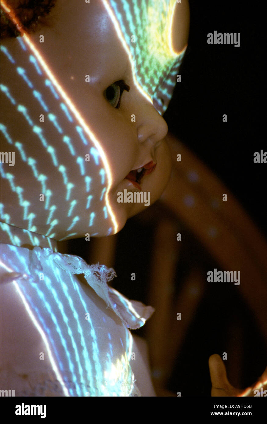 Scary doll in the dark with patterned light shining on its face Stock Photo