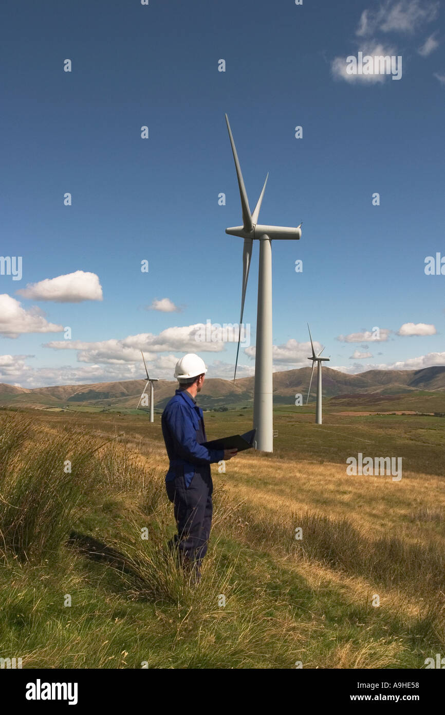 Engineer checking and maintaining wind power turbines producing electricity for part of Cumbria UK at Lambrigg Wind Farm Stock Photo
