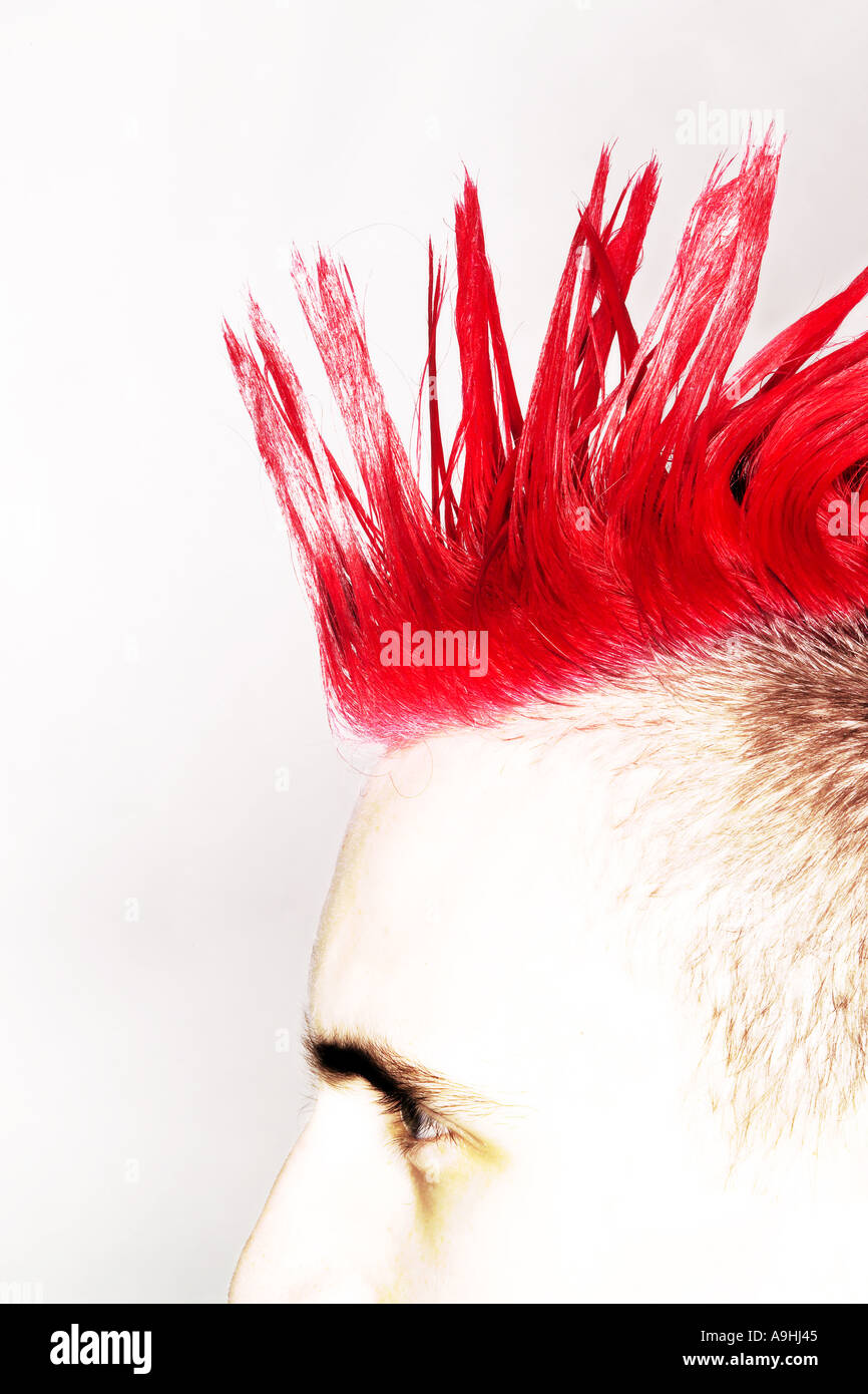 Side view of a young man with a red Mohican hairstyle and shaved sides. Stock Photo