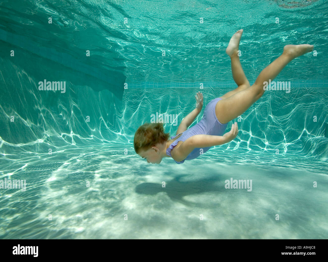 Young girl diving underwater in pool Stock Photo