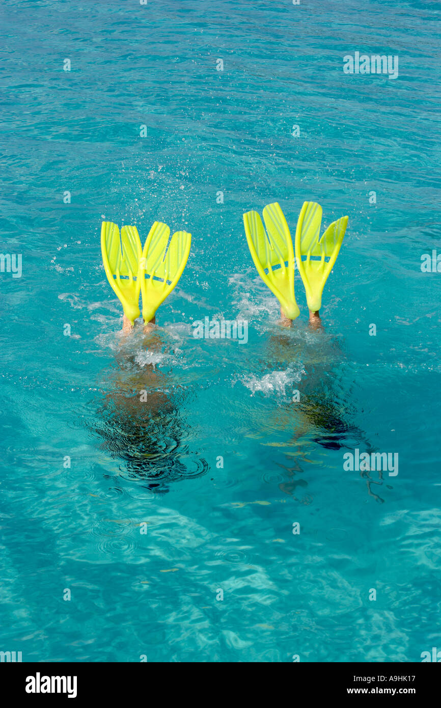 Two snorkelers freedive with fins sticking out of water Playa Azul Cozumel Mexico Stock Photo
