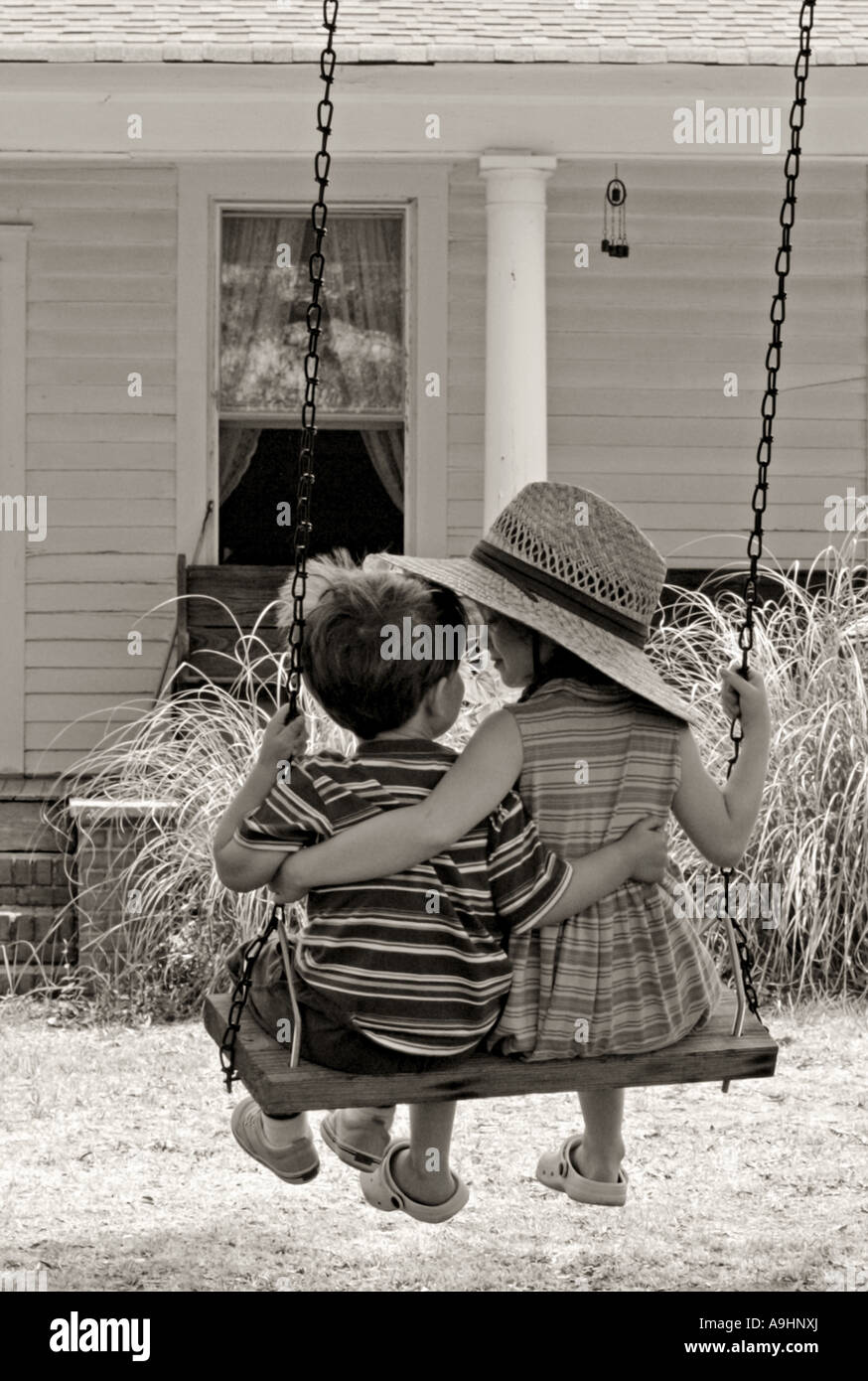 SOUTH CAROLINA YORK Brother and sister with their arms around each other swinging on an old fashioned tree swing Stock Photo