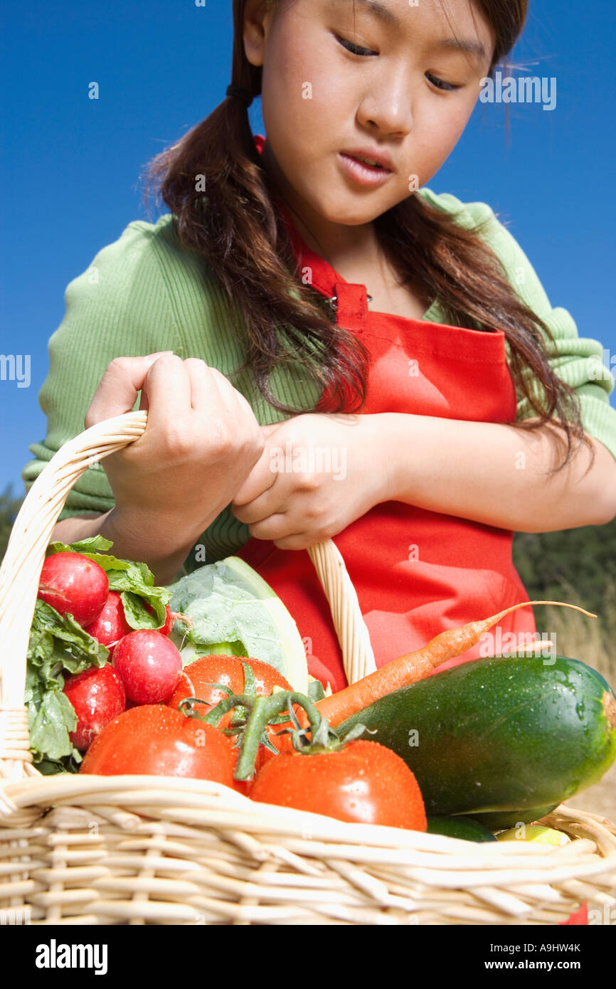 Asian woman carrying basket of fresh vegetables Stock Photo - Alamy