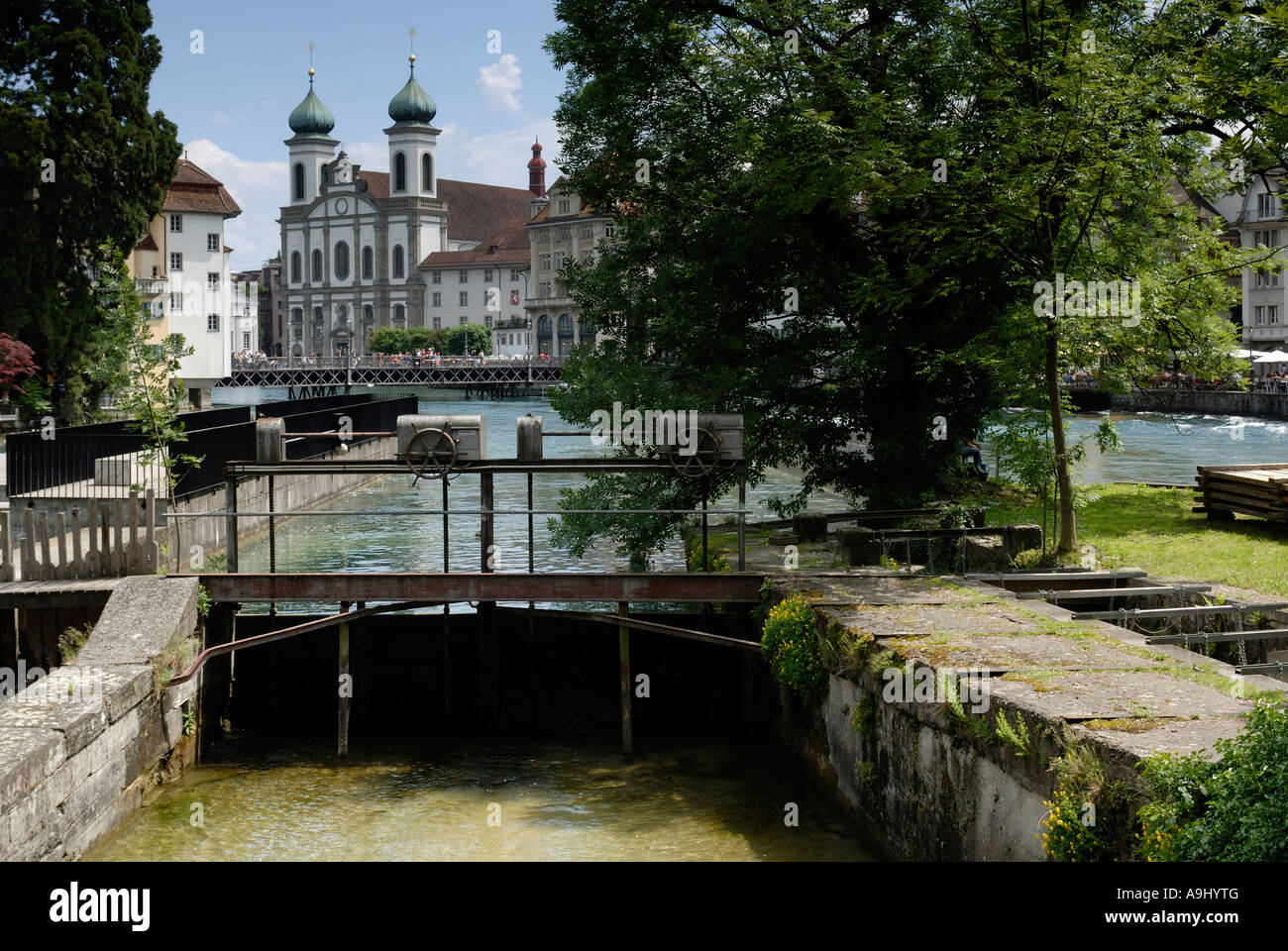 Lucerne - river-weir and a church in the background - Switzerland, Europe. Stock Photo